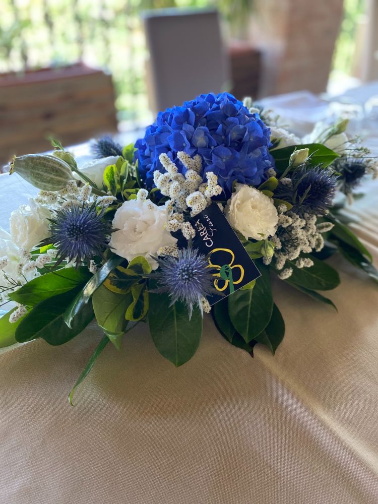 Centro tavola con ortensia blu, lisianthus ed eringium